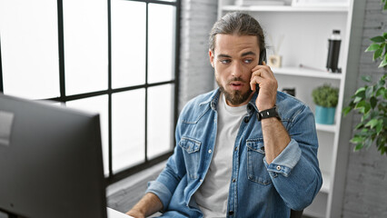 Young hispanic man business worker talking on  smartphone at the office