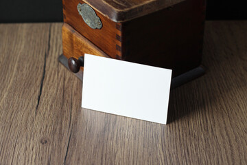 Empty business card mockup with vintage coffee grinder on wooden table background. Mock up for...