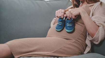 mother, family, maternity, pregnant, woman, pregnancy, baby, motherhood, love, happiness. pregnancy, motherhood, people, close up of happy pregnant woman with big belly sit on sofa and smiling.