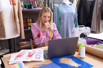 Young caucasian woman dressmaker designer using laptop feeling unwell and coughing as symptom for...