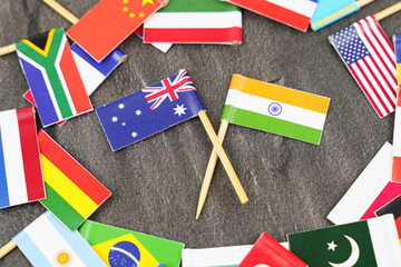 Fototapeta na wymiar The concept is diplomacy. In the middle among the various flags are two flags - India, Australia