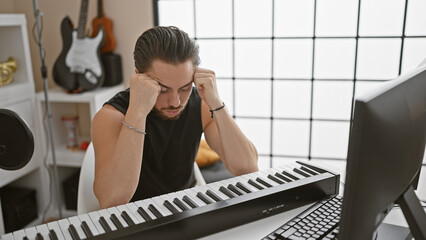 Young hispanic man musician playing piano stressed at music studio