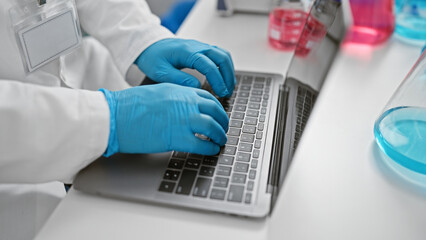 Young hispanic grey-haired man scientist using laptop at laboratory