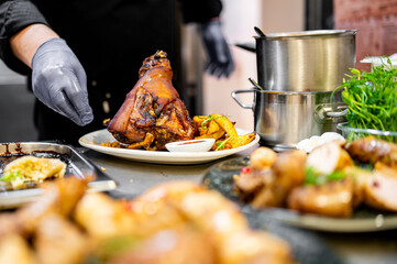 chef hand cooking Baked Pork knuckle