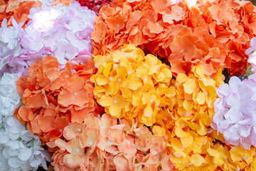 Colorful bunch of fabric and plastic flowers decorated in outdoor garden.