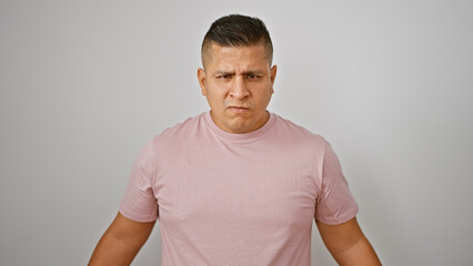 Furious young latin man, a picture of raw anger, standing, fiercely isolated against white...