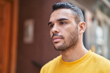 Obraz premium Young hispanic man looking to the side with serious expression at street