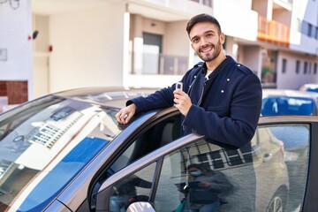 Fototapeta na wymiar Young hispanic man smiling confident holding key of new car at street