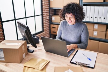Young beautiful hispanic woman ecommerce business worker using laptop sitting on table at office