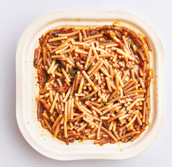 Overhead view of a freshly prepared dish of traditional spanish fideua on a white background.