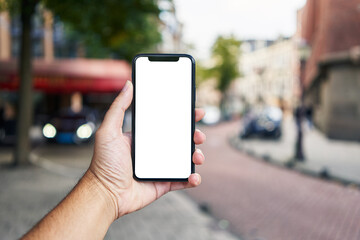 Man holding smartphone showing white blank screen at street