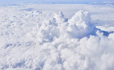 Aerial view of fluffy white cumulus clouds from above, symbolizing nature's tranquility and the beauty of earth's atmosphere.