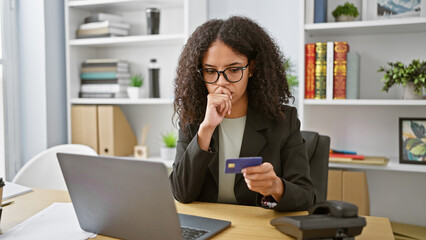 Obraz premium Young beautiful hispanic woman business worker using laptop and credit card thinking at the office
