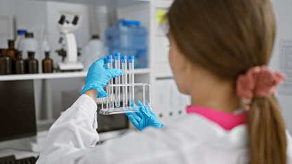 Vibrant young hispanic woman scientist, beautifully engrossed in her work, masterfully maneuvering...
