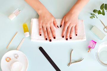 Woman sitting at table with manicure tools