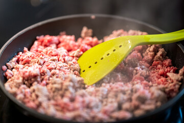 frying mince meat in frying pan.