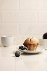 large cupcake on a white background with sprinkles and berries