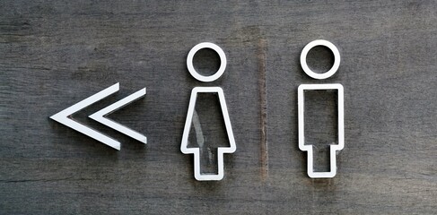 A male and female toilet sign on old wooden background, facility concepts.