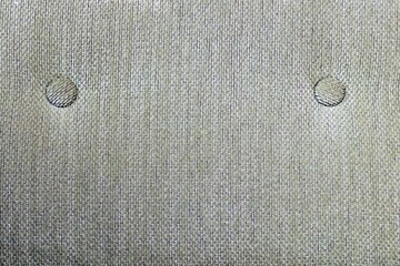 Close up of a grey fabric texture with holes and textured background.