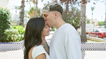 A romantic couple kissing tenderly on a sunlit city street lined with palm trees, embodying love and connection in an urban setting.