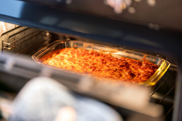 removing finished lasagna from oven