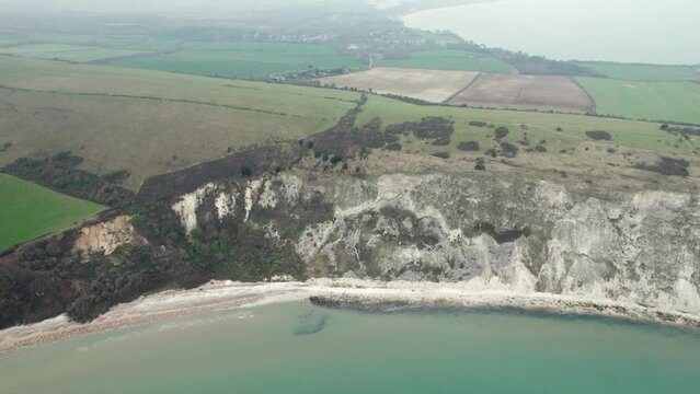 aerial flying across the ballard cliff of Swanage, Travel destination of Dorset, England, overcast day