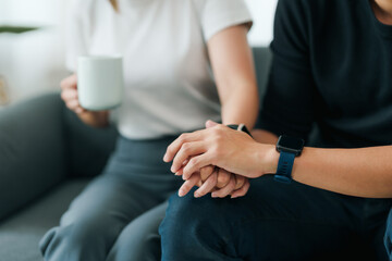 Close-up shot capturing a supportive hand-holding gesture between two people, evoking comfort and empathy..