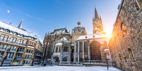 The famous Huge gothic cathedral of The Emperor Karl in Aachen Germany during winter season with snow at Katschhof against blue sky and sunshine background - obrazy, fototapety, plakaty