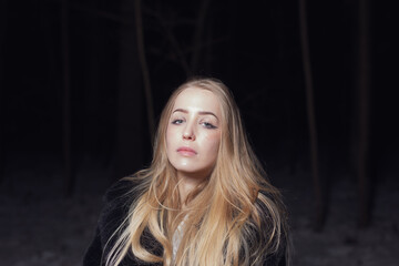 Fototapeta premium young blond woman with blue eyes dancing in the dark night of an very cold snow winter