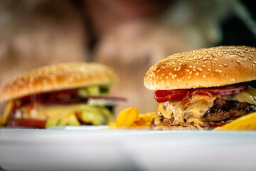 Freshly made bacon cheeseburgers with juicy tomato, lettuce and melted cheese. Food porn, smash burger.