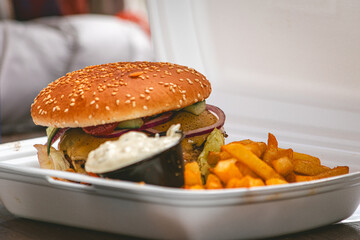 Freshly made bacon cheeseburger with juicy tomato, lettuce and melted cheese with french fries and garlic mayo on the side. Food porn, smash burger.