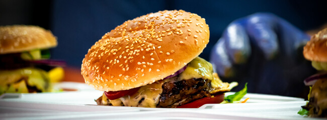 Freshly made bacon cheeseburgers with juicy tomato, lettuce and melted cheese. Food porn, smash burger.
