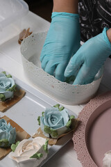 A woman sprinkles homemade zephyr with powdered sugar. Flowers from zephyr. An entrepreneur at...
