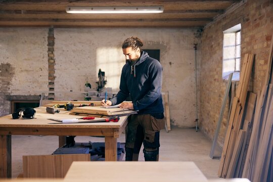 Carpenter working on a design at a workshop bench
