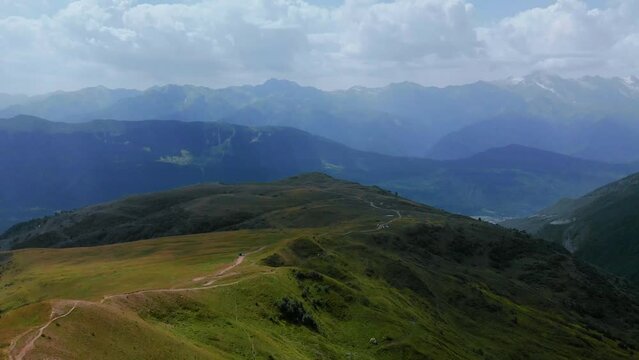 Aerial wide view of mountain tops, warm summer day, clouds in the sky, way to Ushba mountains and Koruldi lakes. Concept of vacation and travel to Georgia. Nature, Mestia, Svaneti.