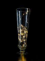 vase transparent avec une guirlande lumineuse à l'intérieur devant un fond noir