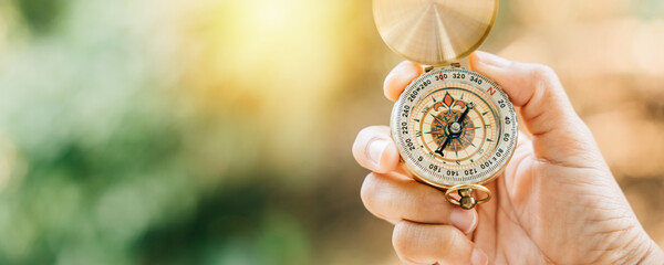 A tranquil forest and peaceful lake set the stage as a woman's hand holds a compass symbolizing...