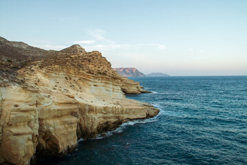 Olas batiendo los acantilados en Las Negras, Almería, España. Paisaje costero del Parque Natural Cabo de Gata a orillas del mar Mediterráneo.