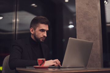 Young business man working on a laptop at his office during the night.