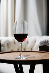 Glass with red wine on wooden table in restaurant