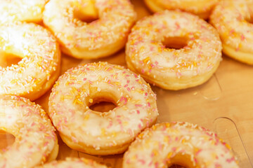 Many donuts with yellow icing on the counter in a store. Traditional mouth-watering sweets. Close-up.