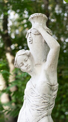 Kyiv, Ukraine, 03.08.2023. sculpture of a girl in the spring park. An old statue in a park of a semi-nude Greek or Italian Renaissance woman with a vase in a city park. in the summer garden. editorial