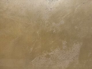 Gold or golden textured paint washed on a wall or panel, seamless texture, random texture. No people