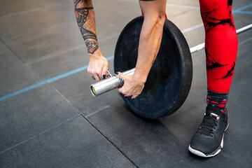 Woman securing a clamp at a weightlifting bar