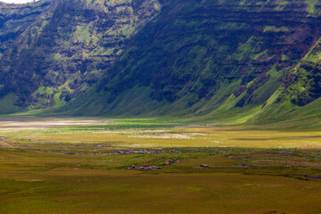 Landscape of green hills in the mountains on a cloudy day. Location of Mount Bromo in Bromo Tengger Semeru National Park, East Java, Indonesia