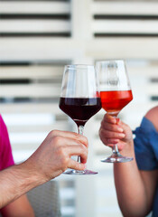 Two wineglasses in the hands of man and woman