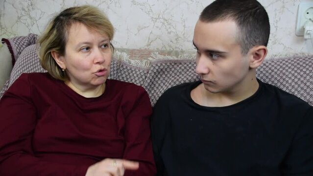 A teenager and a mother communicate in front of a laptop and discuss upcoming plans for the week.