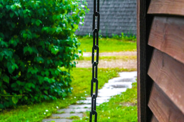Chain in the rain at wooden house in Germany.
