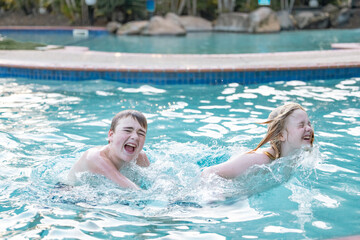 Brothers enjoying resort pool on vacation