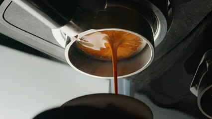 Coffee espresso machine pulling double shot espresso from bottomless naked portafilter. 